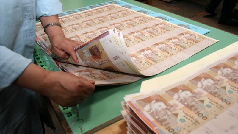 أوراق نقدية موضوعة على مكتب بنكي ترمز إلى الودائع البنكية والسيولة المالية داخل النظام المصرفي بالمغرب.